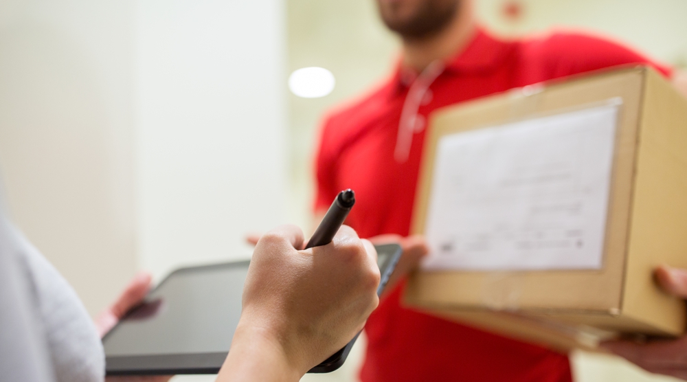 Lieferservice Jemand unterschreibt für ein geliefertes Paket